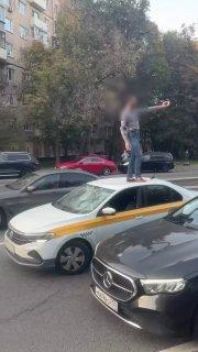 В Москве мужчина устроил странный перформанс: прыгал по чужим автомобилям, а затем пробежался по полицейской машине.