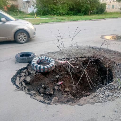 Огромная яма образовалась на Филатова. Местные накидали ветки и покрышки,...