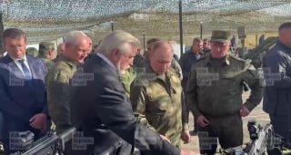 Путин в камуфляже взял в руки пистолет и зарядил обойму.
